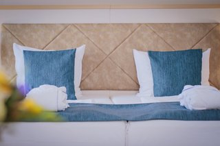 Bright, modern hotel room featuring a beach view, a cozy lounge chair, and a desk, creating a serene and inviting atmosphere.