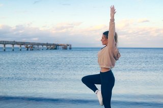 A couple enjoys a toast in a pool at sunset, surrounded by palm trees and lounge chairs, radiating a relaxed and romantic atmosphere.